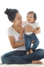 Young beautiful mother and her children baby smile happy ware white cloth and blue jean trouser on isolated white background